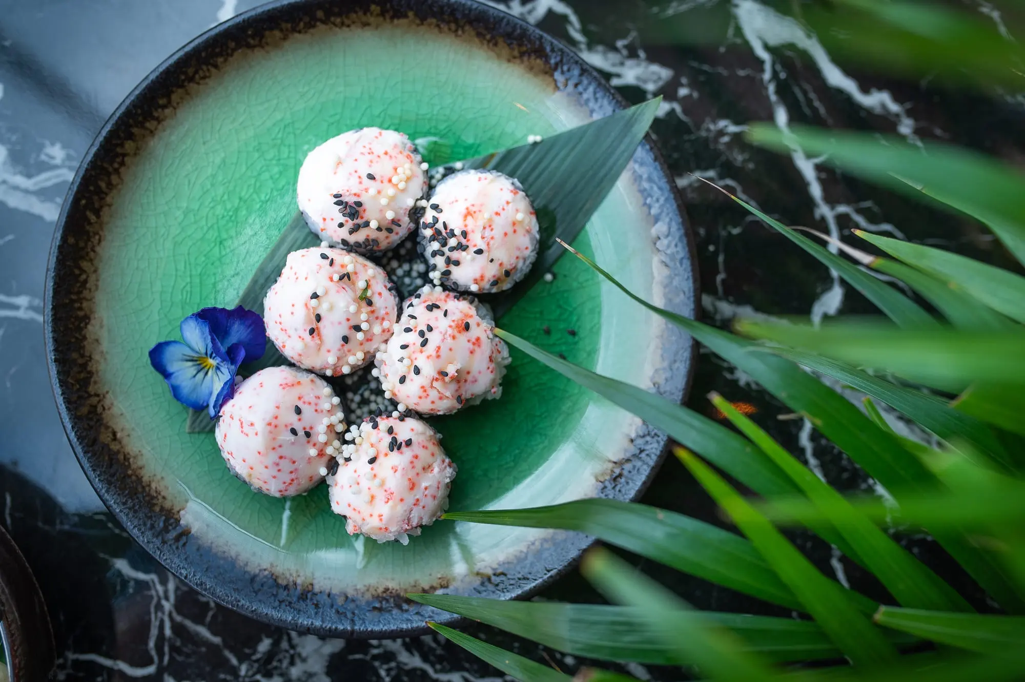 Kuleczki ryżowe z sezamem podane na liściu bambusa w Sushi Okami 2.0