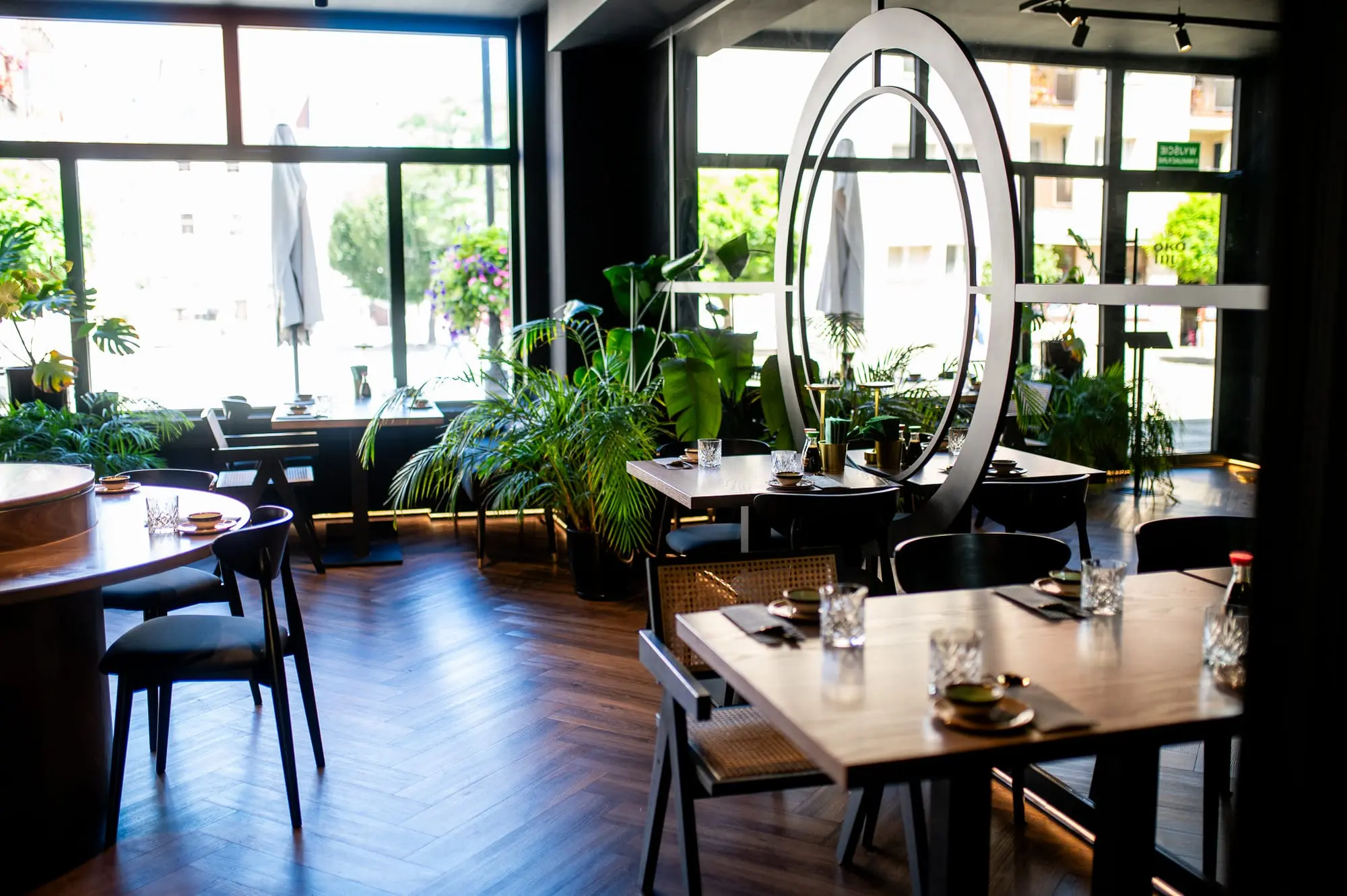 Wnętrze restauracji Sushi Okami 2.0 w Oleśnicy — jasna sala z roślinami i eleganckim wystrojem