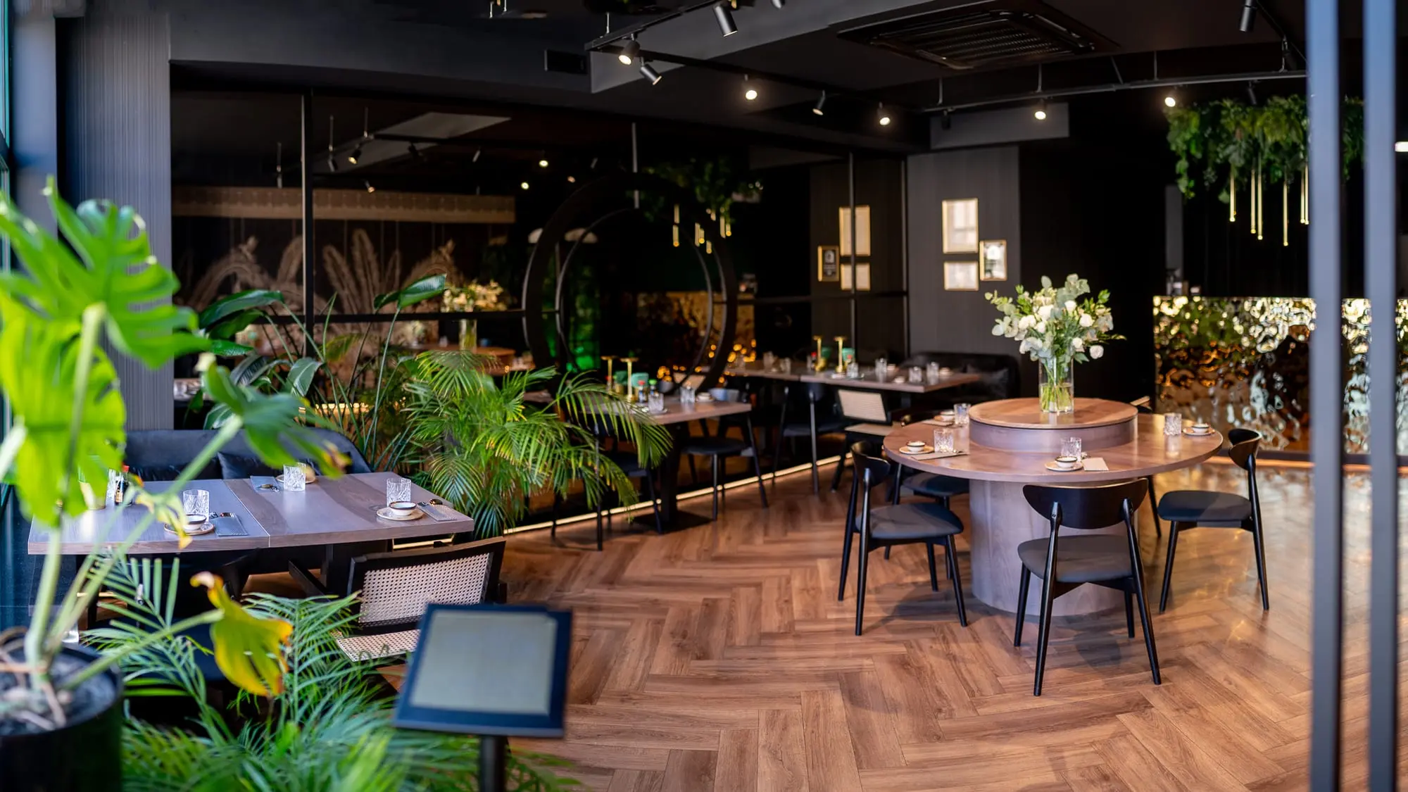 Przytulne wnętrze Sushi Okami 2.0 Oleśnica — drewniana podłoga, rośliny i nowoczesny design