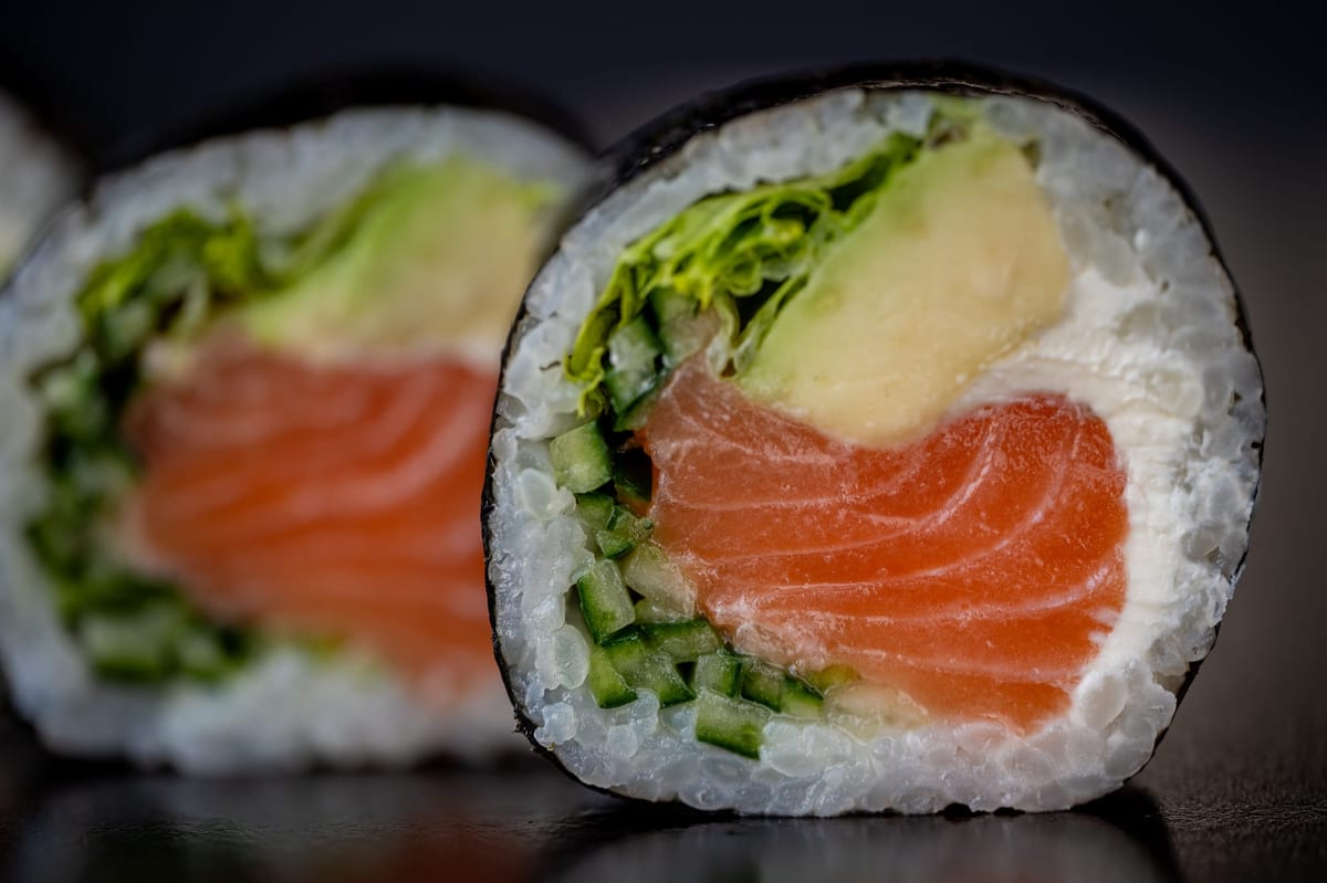 Grube rolki futomaki podane na drewnianej desce w restauracji sushi w Oleśnicy